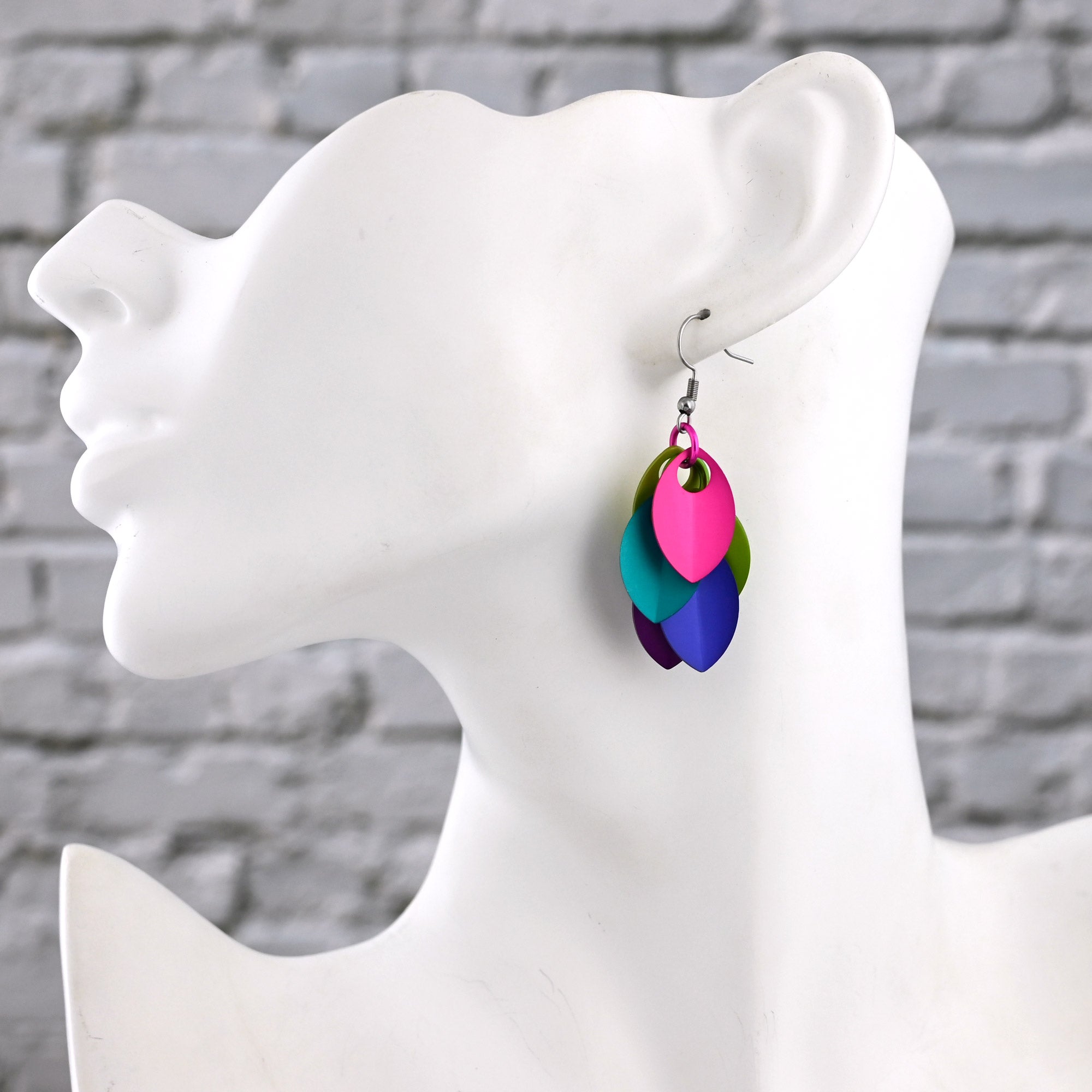 Side view of a white mannequin wearing the short Electric Rainbow dangles, showing them resting just below the ear. From this angle, the hot pink, aqua and purple links are prominent.