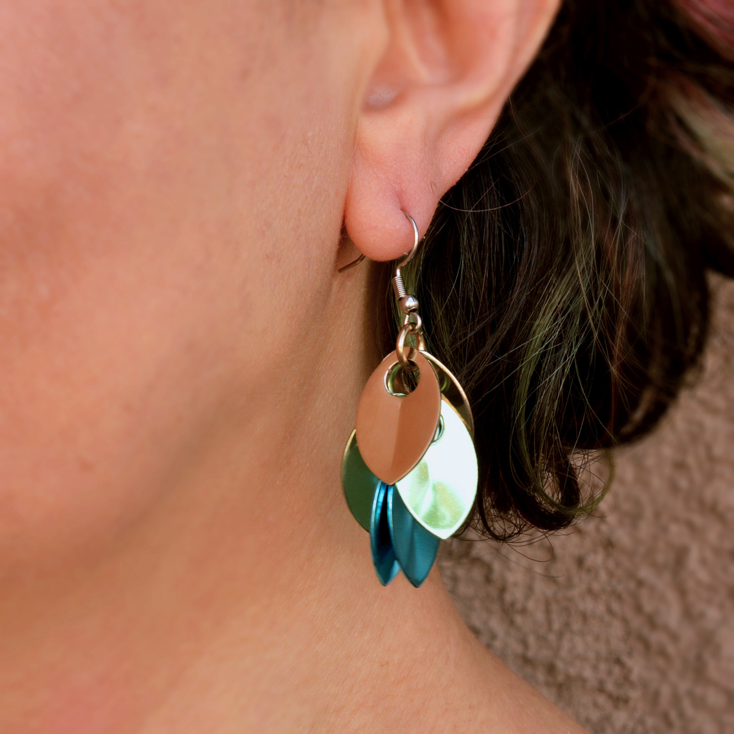 Close-up of Rebeca Mojica wearing the seashell ombre dangle earrings, focusing on how they look on the ear and the gentle curve of the design.