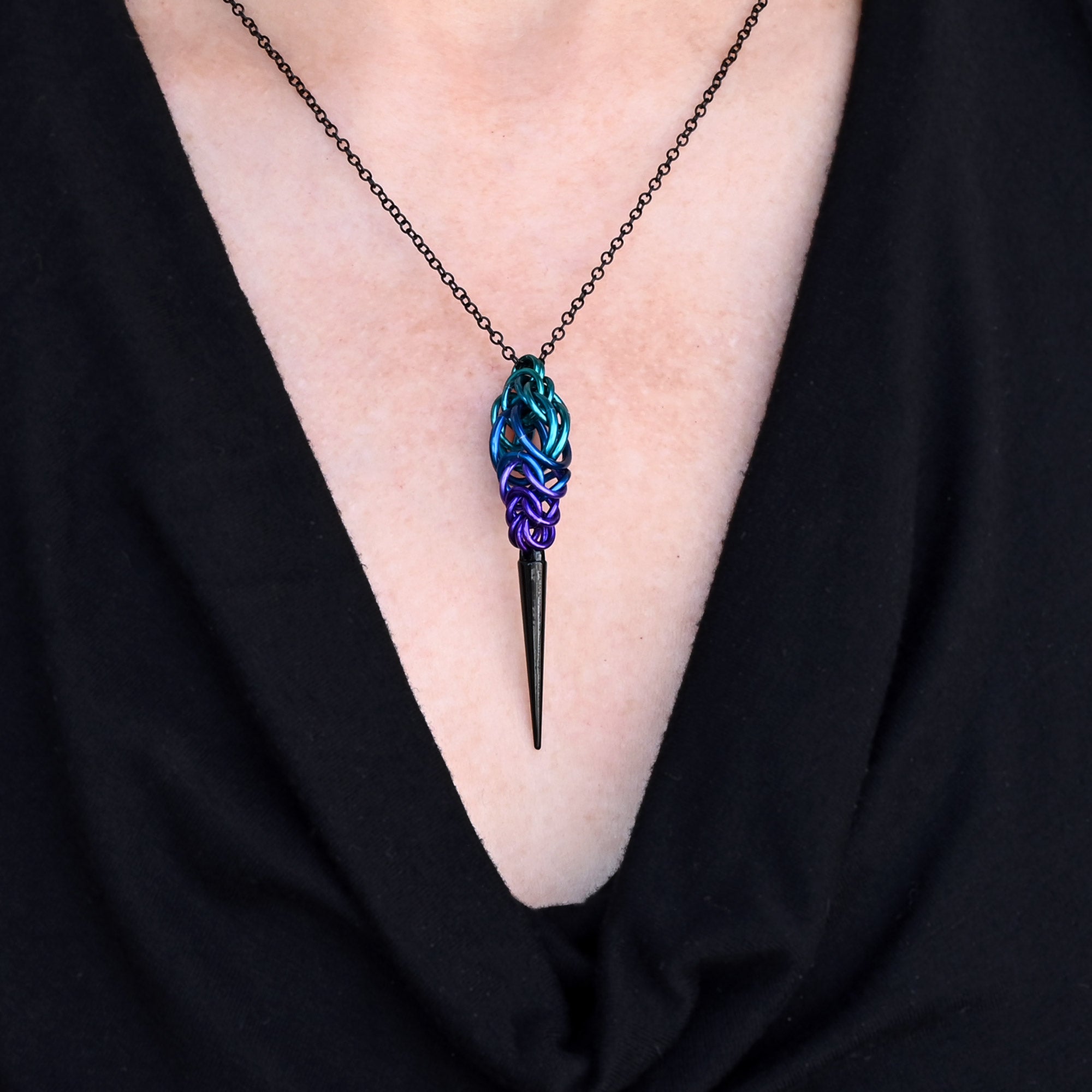Close-up of a person wearing the Dark Mermaid chainmaille Spike Pendant over a black V-neck top, showing how it sits on the neckline.