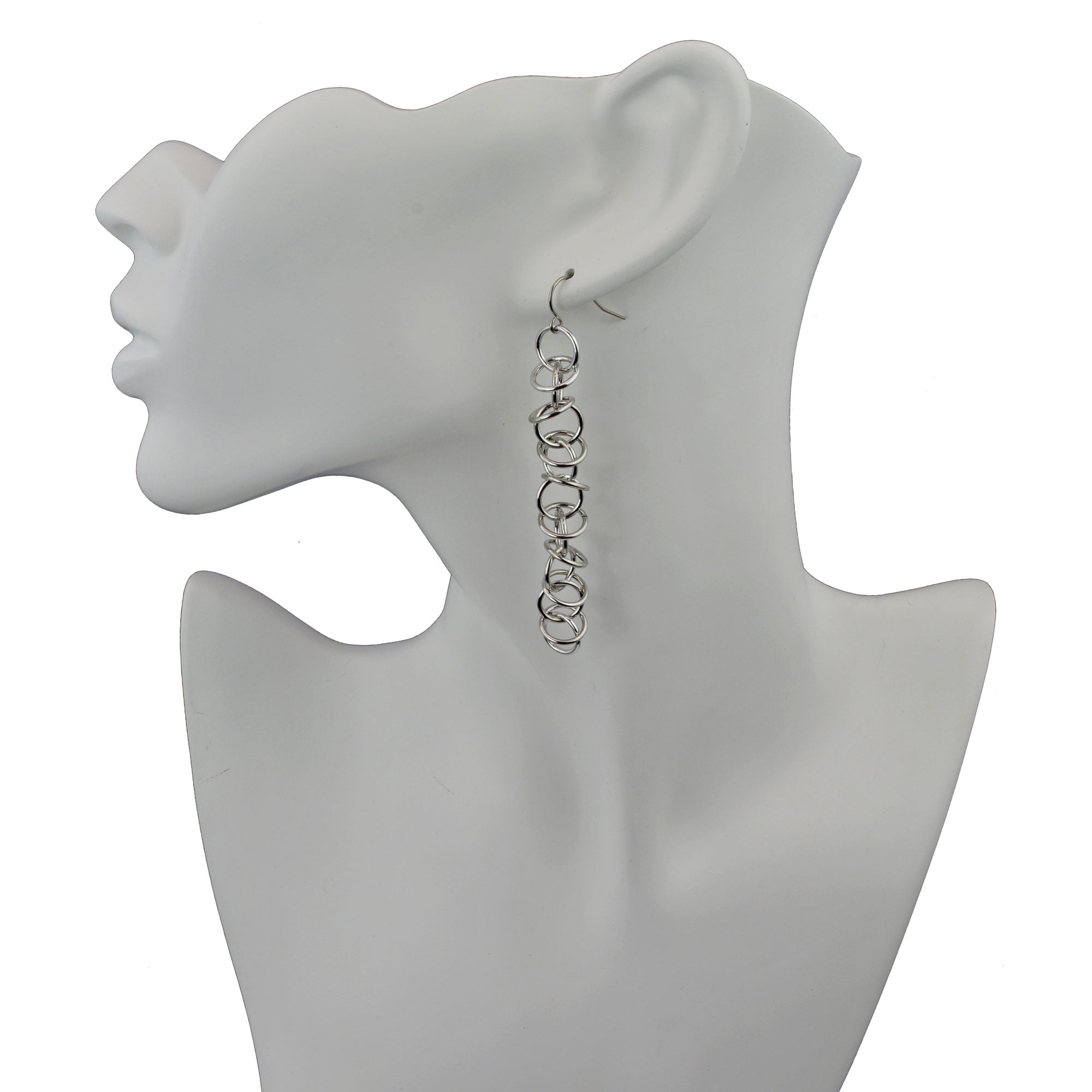 Long silver orbital earrings on white display form.