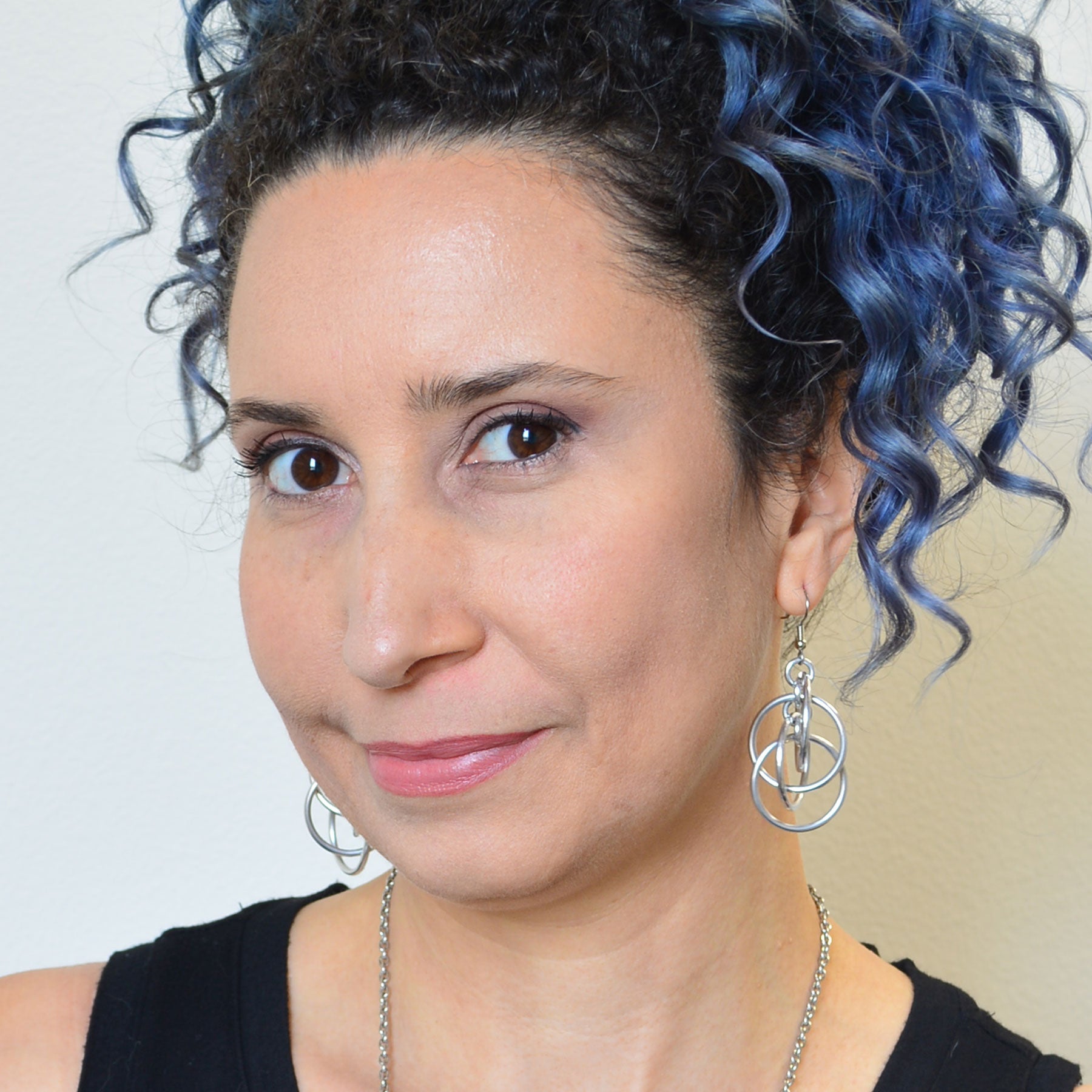 Artisan Rebeca Mojica wearing a silver version of the intertwined hoops earrings