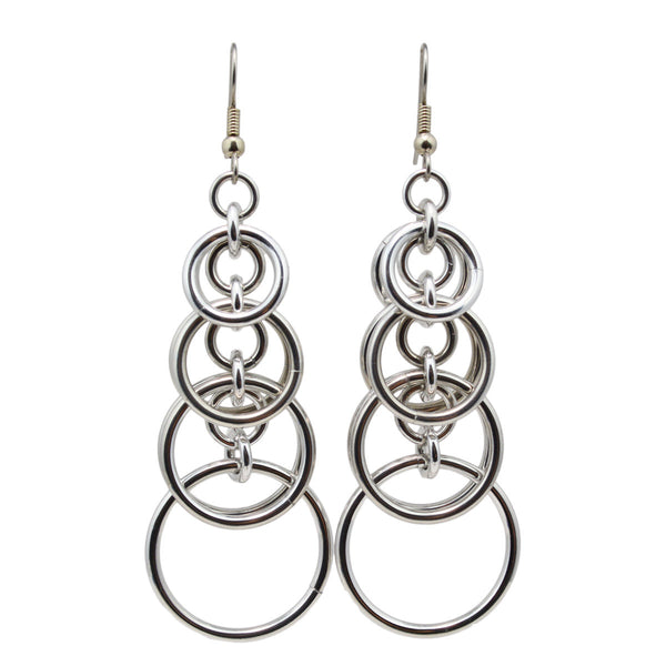 Statement earrings in silver color on a white background. Earrings consist of interlocked hoops that stack and become larger as you move down the earring - the final hoop is 3/4" around
