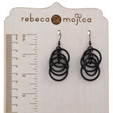  Black intertwined hoop chainmaille earrings on a branded wooden stand, shown with a ruler to display the 2.5-inch length.