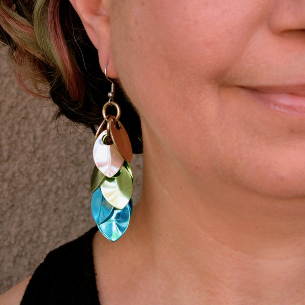 A close-up photo of one of the scalemaille earrings being worn, showing the detail of the aluminum scales and how the surgical steel earwire sits comfortably in the ear.