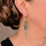 Chainmaille artisan Rebeca Mojica wearing one of her handmade Seashell Ombre Spike Earrings to show the scale and how it looks when worn.