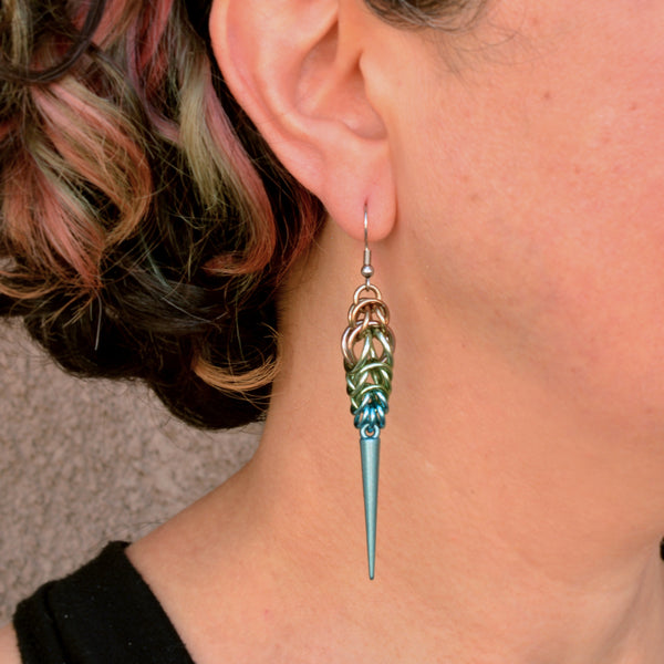Chainmaille artisan Rebeca Mojica wearing one of her handmade Seashell Ombre Spike Earrings to show the scale and how it looks when worn.