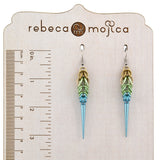 A pair of Rebeca Mojica Seashell Ombre Spike Earrings on a branded display board, with a ruler showing the length is about 3.25 inches.