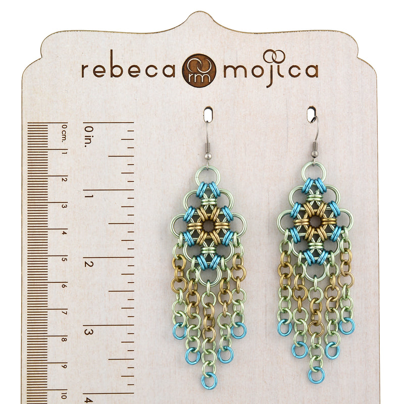 Seashell chandelier chainmaille earrings displayed on a wooden display stand with a ruler alongside to show the 4-inch length.