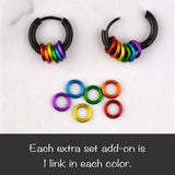 Two black rainbow pride huggie earrings, one open and one closed. Below is a set of six extra colored links (red, orange, gold, green, blue, purple) and text "Each extra set add-on is 1 link in each color."