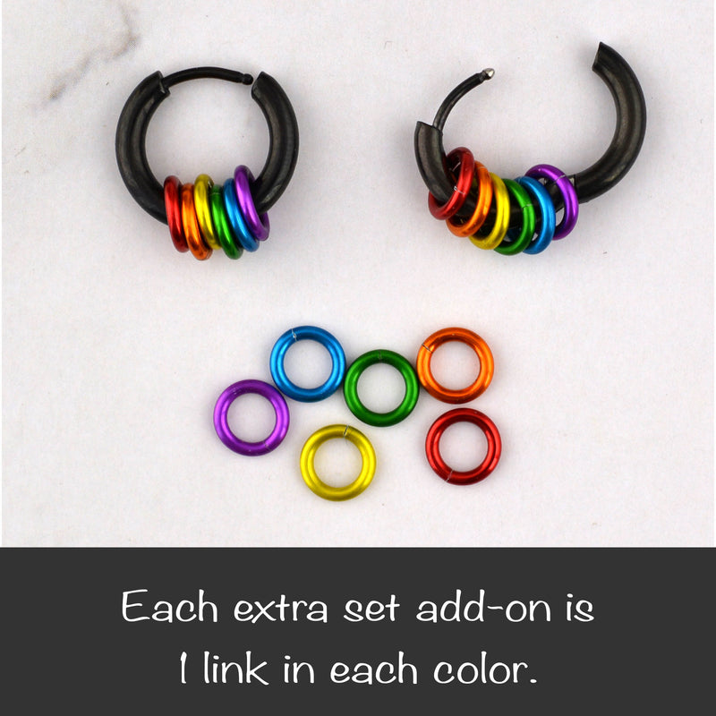 Two black rainbow pride huggie earrings, one open and one closed. Below is a set of six extra colored links (red, orange, gold, green, blue, purple) and text "Each extra set add-on is 1 link in each color."