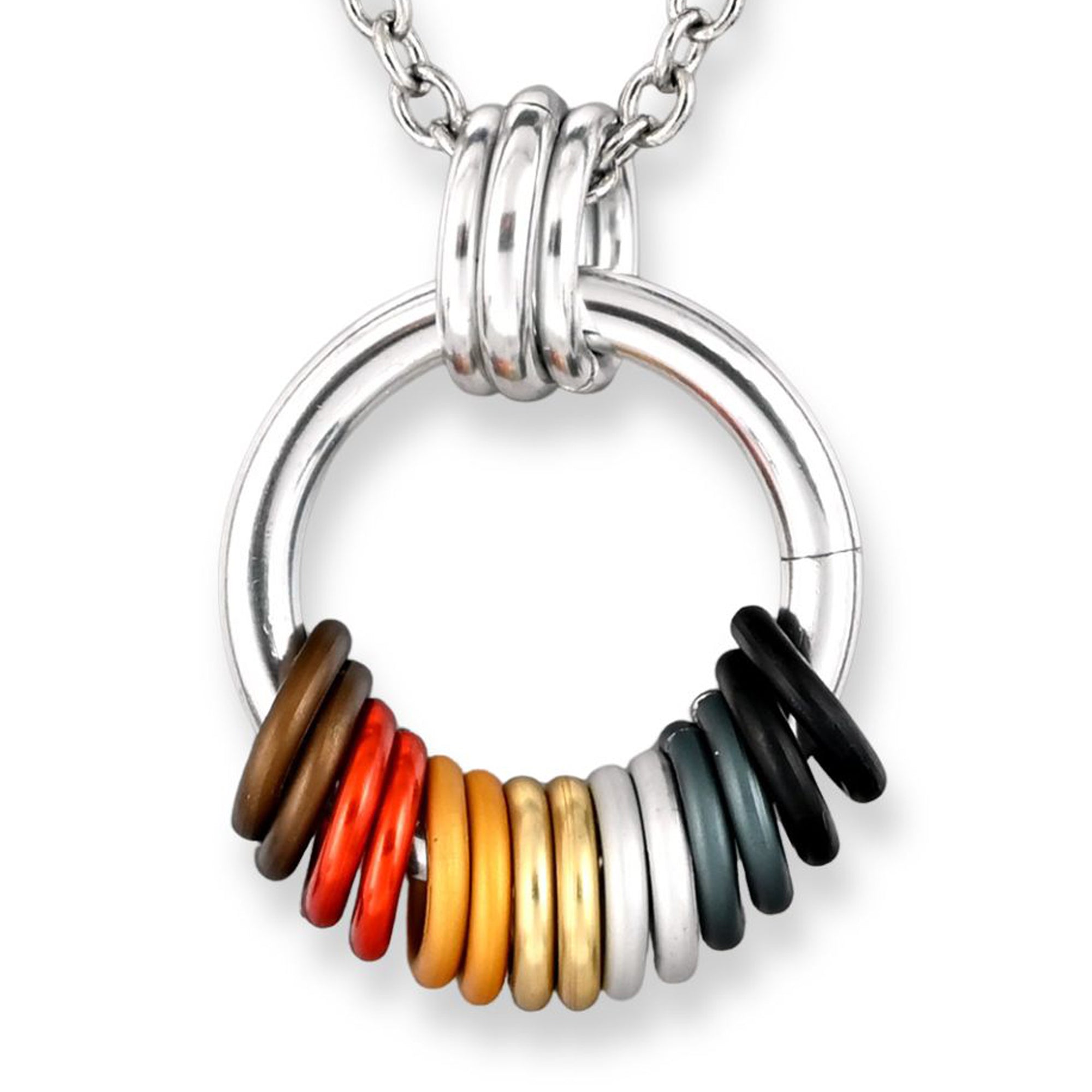 Closeup of a  chainmaille pendant with a  thick silver color link and a coil of free-spinning rings in the Bear Brotherhood flag colors: brown, orange, yellow, white, and black. The rings are arranged in a tactile sequence at the base of the main silver color link.