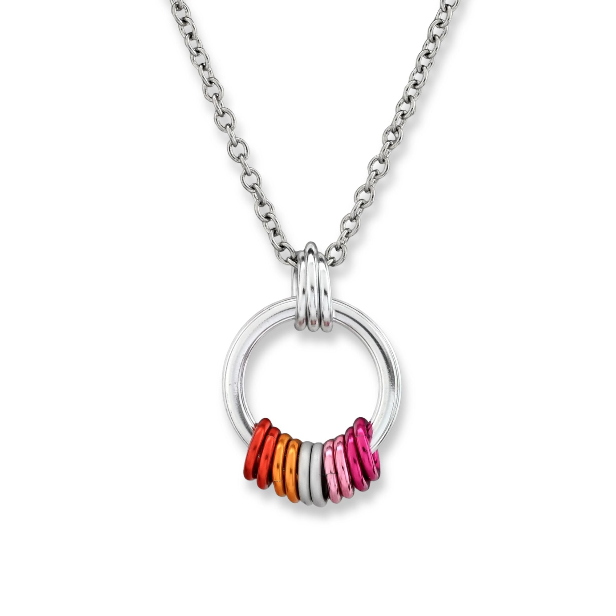 A minimalist silver pendant on a white background featuring a series of colorful rings in the colors of the Lesbian Pride flag sunset gradient: dark orange, light orange, white, light pink, and dark pink.