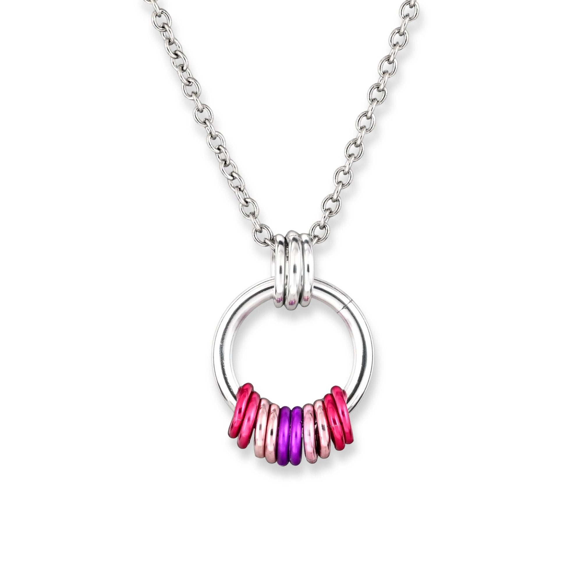 A minimalist silver ring pendant with smaller free-spinning aluminum rings displayed against a white background. The 10 colorful aluminum links at the base are arranged side by side, forming a coil shape, with groups of 2 links in the Sapphic pride colors: dark pink, light pink, violet, light pink and dark pink.