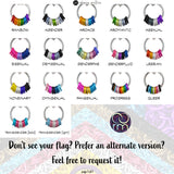 A comprehensive swatch chart displaying various Pride Flag Coil Fidget Necklaces. Each example shows a silver coil with different colored aluminum rings, representing flags such as Rainbow, Agender, Aromantic, Bisexual, and Transgender (bold/light). Text at the bottom invites customers to request custom flag designs if not shown.