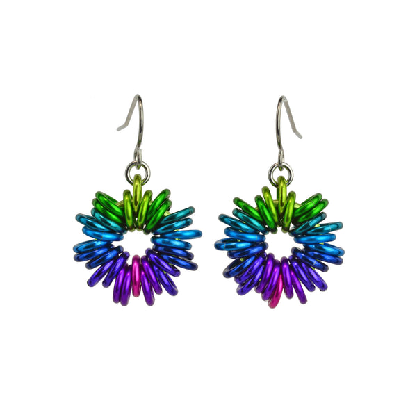 Electric Rainbow Coiled Earrings by Rebeca Mojica Jewelry. Each earring has 28 colorful jump rings added to a single large ring; the overall look resembles coiled wire.