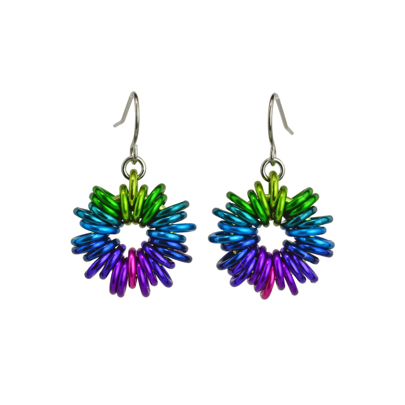 Electric Rainbow Coiled Earrings by Rebeca Mojica Jewelry. Each earring has 28 colorful jump rings added to a single large ring; the overall look resembles coiled wire.