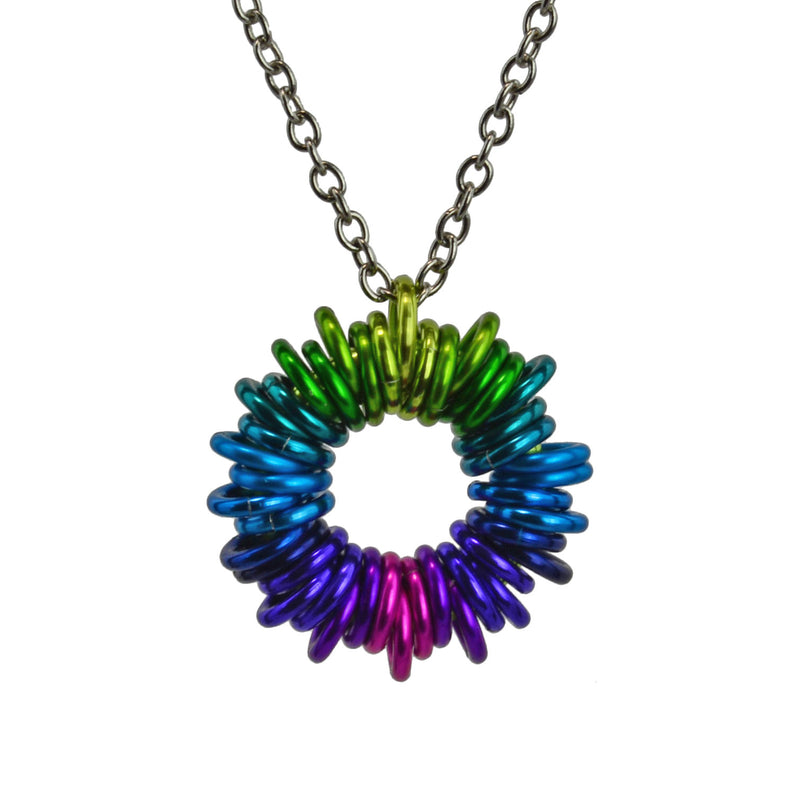 Closeup of Coiled chainmaille Pendant in Electric Rainbow colorway by Rebeca Mojica