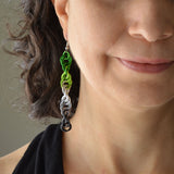 Closeup of the bottom right quadrant of a woman’s face wearing a chainmaille spiral earring in the aro pride colors - green, lime, white, grey and blac