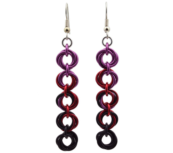 Chainmaille earrings of 5 linked "knots" hanging from the earwire on white background. Top knot is dusty rose transitioning as you move down the earring to garnet and black.