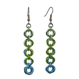 Chainmaille earrings of 5 linked "knots" hanging from the earwire. Top knot is pastel green, transitioning as you move down the earring to chartreuse and light blue. chainmaille earrings by Rebeca Mojica