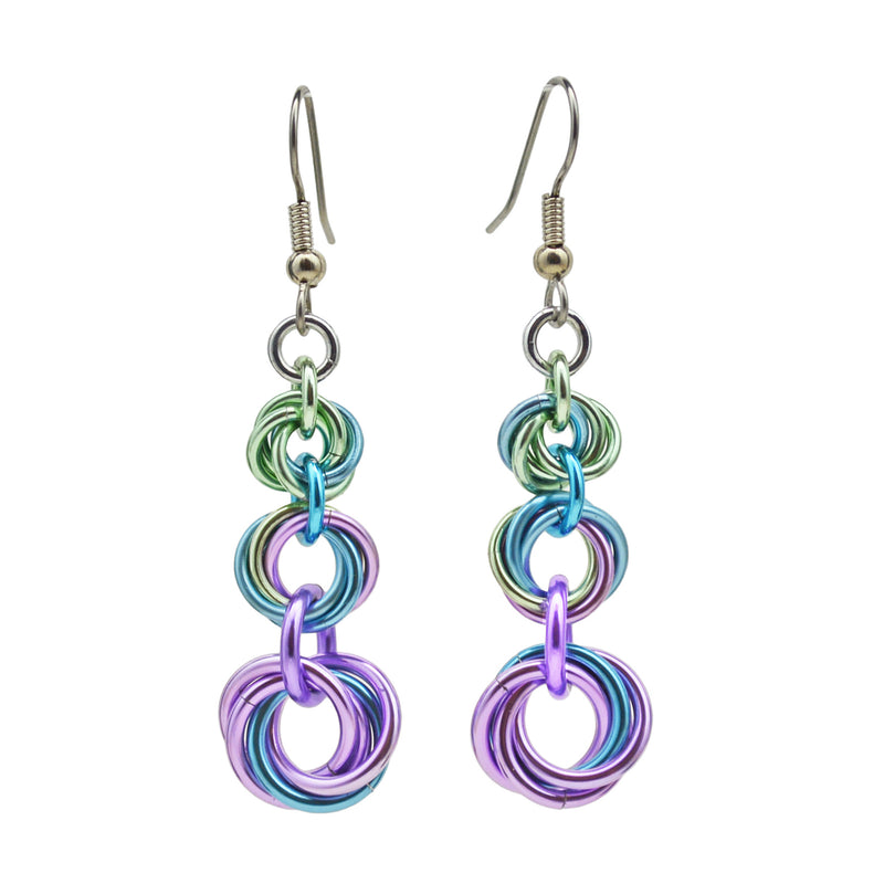 A pair of hainmaille earrings against a white background. Three "knots" (each made of 4 anodized aluminum jump rings swirled together) cascade in an elegant drop shape. The smallest knot at top is seafoam with a bit of blue, the middle knot is seafoam, light blue and lilac, and the largest knot at the bottom is mostly lilac with one link of light blue.