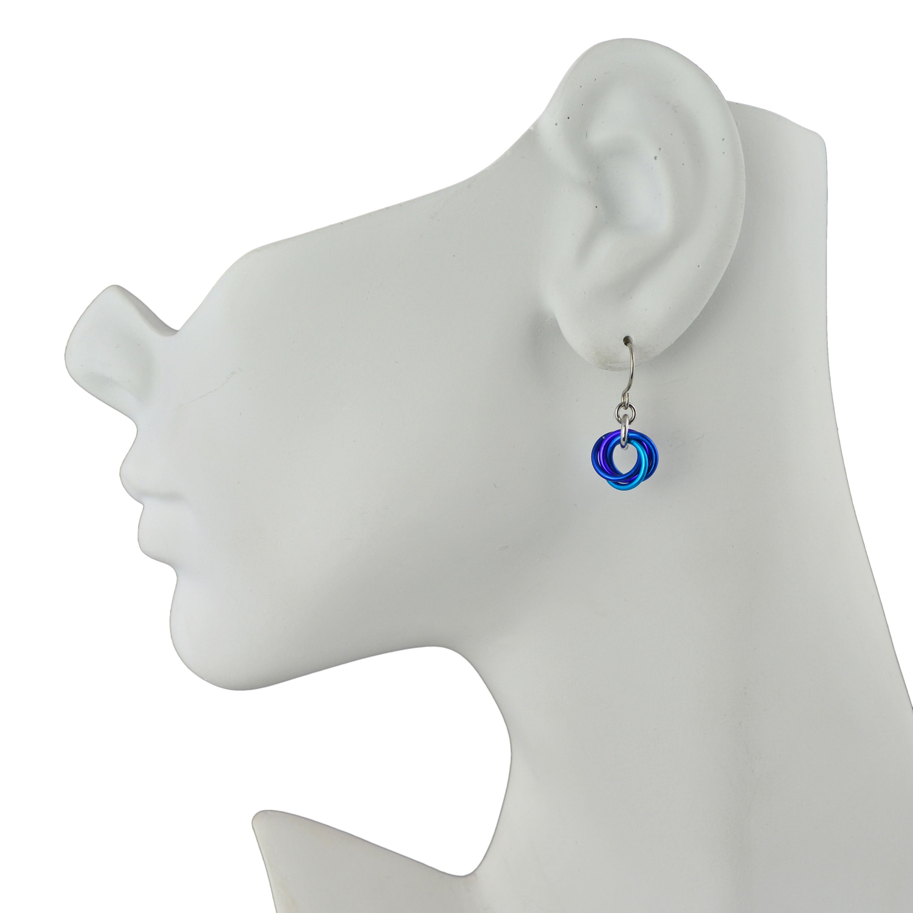 Mini Knot chainmaille earrings in water colorway (blue, purple, turquoise) on white jewelry display head in profile, on white background