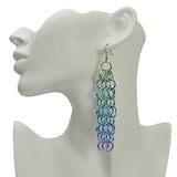 Large link chain mesh long statement earring in a pastel ombre that almost looks iridescent. Links are pastel green at the top, transitioning to light blue in the middle and lavender at the bottom. Earring is hung on the earlobe of a white display head