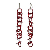 Another view of the chainmaille Long Orbital Red earrings by Rebeca Mojica, showing that the earrings look different from different viewpoints.