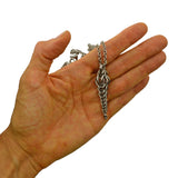 Auger Pendant by Rebeca Mojica held in hand to show scale. Pendant length equals about 3 fingers width.