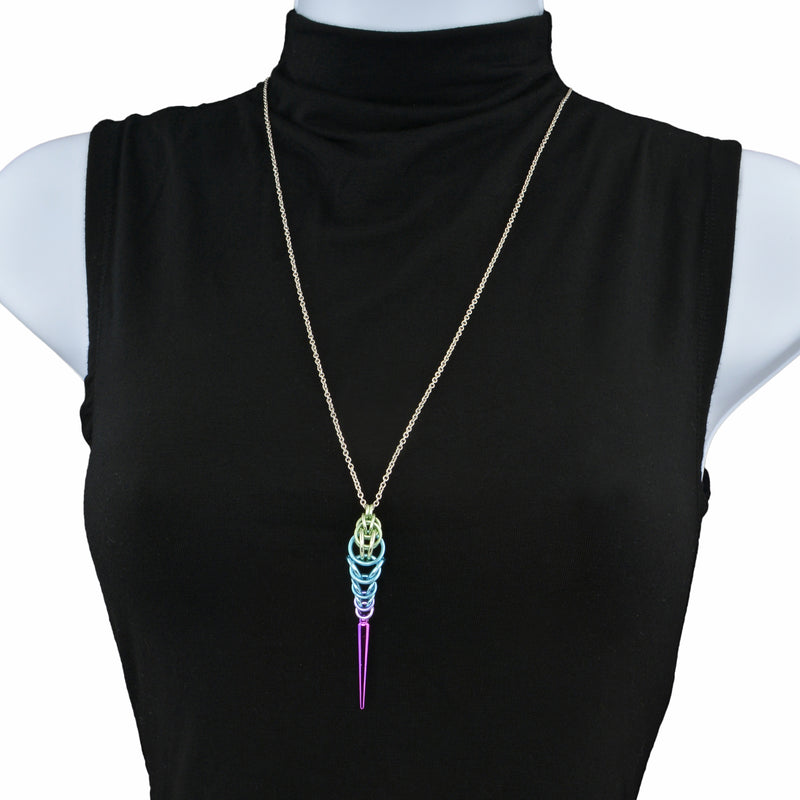 Chainmaille pendant on a stainless steel chain displayed on a torso form with a black turtleneck shirt. The pendant is made of chainmaille and is seafoam at the top, sky blue in the middle and lilac at the bottom, with a long lilac spike at the base.