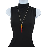 Chainmaille pendant on a stainless steel chain displayed on a torso form with a black turtleneck shirt. The pendant is made of chainmaille and is gold at the top, orange in the middle and red at the bottom, with a long red spike at the base.