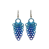 Mesh cluster earrings feature a large light blue jump ring at top, with a mesh hanging and tapering to a point. The upper mesh rings are light blue, transitioning to turquoise and finally dark blue at the bottom tip. The chainmaille pattern is European 4-in-1.