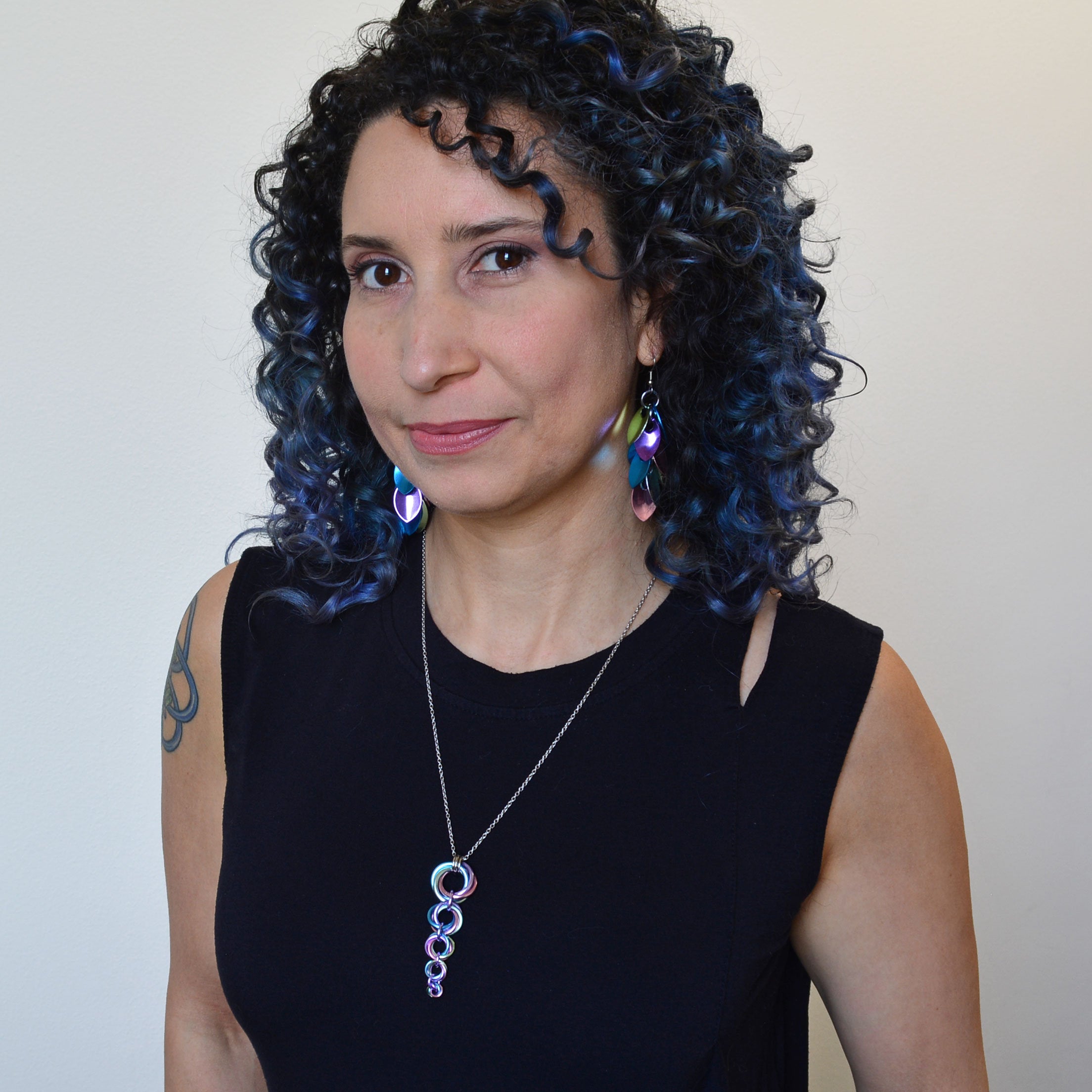 woman in black top wearing unicorn horn pendant