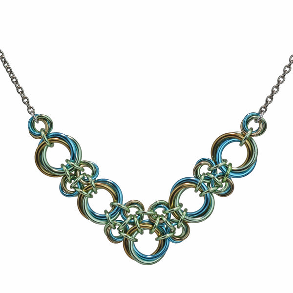 Chainmaille necklace made of 3-ring knots in a V shape in seafoam, light blue and champagne by Rebeca Mojica.