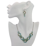 Chainmaile Knot necklace in V shape with coordinating earrings on white display form. Seashell colorway: seafoam, light blue and champagne.